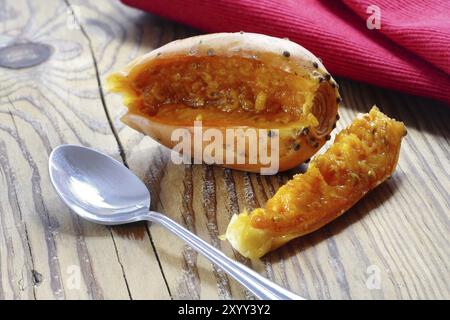 In Scheiben geschnittene Feigenbirne und eine Ruhe auf einem rustikalen Holzbrett, Löffel und rote Serviette Stockfoto