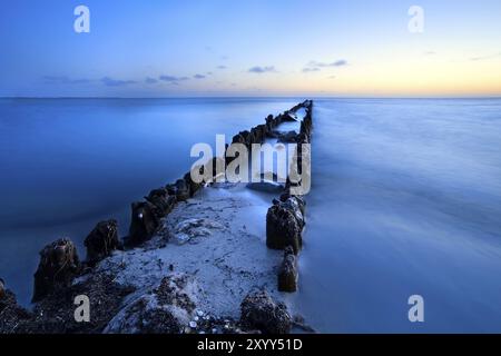 Langer alter Holzdeich in der Nordsee in der Abenddämmerung, Niederlande Stockfoto