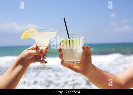 Zwei Cocktailgläser im Mann und in der Frau die Hände. Margarita und Mojito cocktail Stockfoto