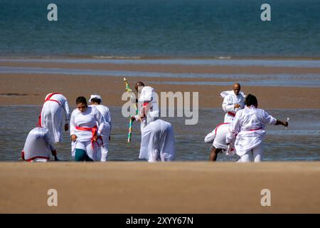 Jesus White Gewand biblisches rotes Schärpe; christliche Gruppe, die im Meer in Southport, Großbritannien, badete Stockfoto