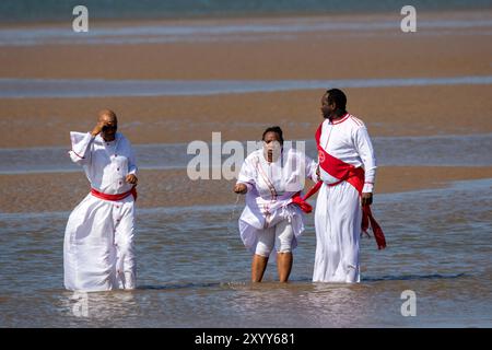 Jesus White Gewand biblisches rotes Schärpe; christliche Gruppe, die im Meer in Southport, Großbritannien, badete Stockfoto