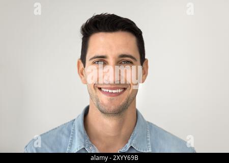 Ein glücklicher, gutaussehender junger hispanischer Model, der in die Kamera schaut Stockfoto