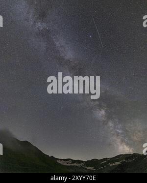 Nächtlicher Sternenhimmel über dem Furka-Pass in den Schweizer Alpen. Das Nachtfoto zeigt die Sterne der Milchstraße und Sternschnuppen. Obergoms, Wallis Stockfoto