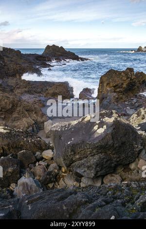 Meereslandschaft mit Wellen, die auf den Felsen in Seixal, Madeira Stockfoto