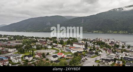 Panoramablick auf Stord Stadt Norwegens mit Bergen im Hintergrund unter einem bewölkten Himmel Stockfoto