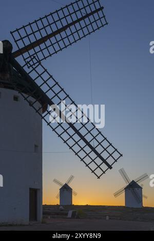 Nahaufnahme einer Windmühle im Vordergrund mit zwei weiteren am Horizont bei Sonnenuntergang, Windmühlen, Campo de Criptana, Provinz Ciudad Real, Castilla-La man Stockfoto