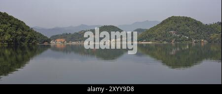 Hügel bedeckt von grünen Wäldern, die sich im See Begnas, Nepal, Asien spiegeln Stockfoto