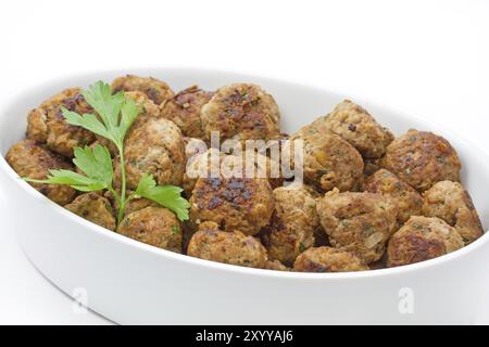 Frisch gebratene Fleischbällchen in eine Schüssel geben. Stockfoto