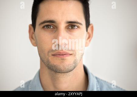 Ernsthafter Lateinmann, der in die Kamera schaut, um Gesichtsaufnahmen zu machen Stockfoto