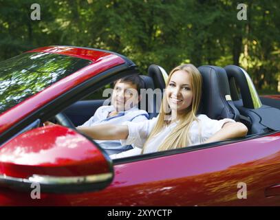 Glückliches Paar in roten Cabriolet an einem sonnigen Tag Stockfoto