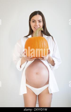 Schwangere Frau mit großen Kürbis. Gesundes Konzept. Nahaufnahme Stockfoto