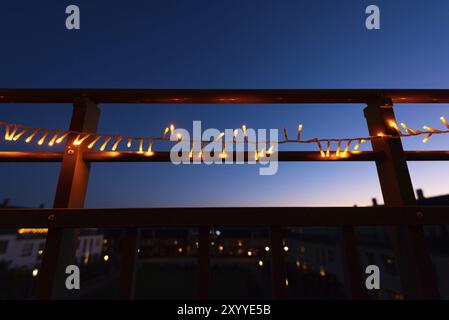 Weihnachtslichter am Geländer eines Balkons in der Nacht Stockfoto