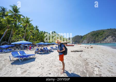 Touristen an einem Sandstrand mit Liegestühlen, tropische Insel mit Palmen und türkisblauem Meer, Isla Tortuga, Provinz Puntarenas, Costa Rica, Zentrum Stockfoto