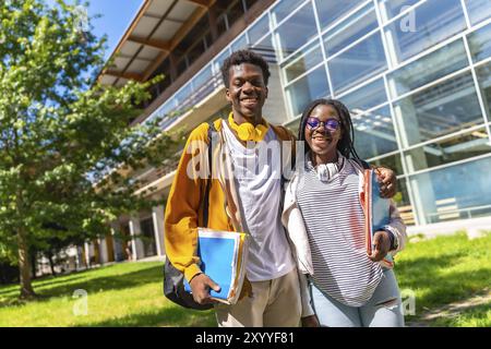 Porträt zweier stolzer und glücklicher afrikanischer Universitätskollegen, die draußen auf dem Campus stehen Stockfoto