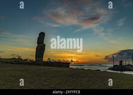 Silhouette der einzigen Moai am Fischereihafen im Dorf von Hanga Roa auf Rapa Nui Insel bei Sonnenuntergang Stockfoto