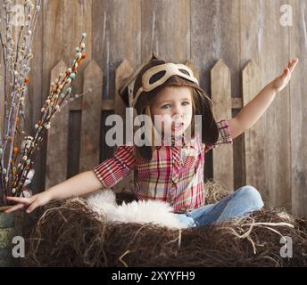 Glückliches Kind spielen in pilot Helm in der Nähe von hölzernen Hintergrund Stockfoto