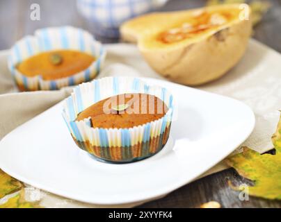 Kürbis-Muffins mit Samen und Kürbis auf dem hölzernen Hintergrund Stockfoto