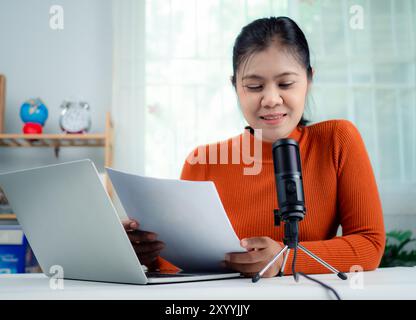 Podcast, Webinar, Konzept für Content Creator, Frau, die am Stand in das Mikrofon spricht, Online-Kommunikation leiten, Thema diskutieren, Notebook-Bildschirm betrachten Stockfoto