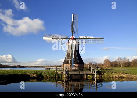 Charmante niederländische Windmühle am blauen See Stockfoto