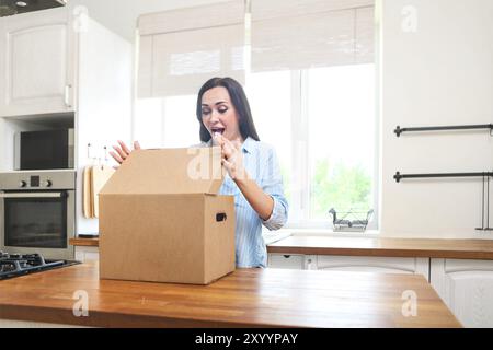 Junge Frau mit Kasten in Ihrem Haus in oder aus einer Wohnung Stockfoto