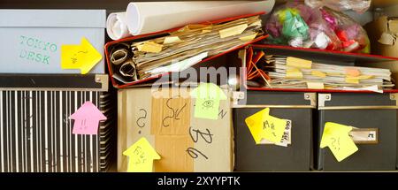 Unordentliche Aktenordner und Aufbewahrungsboxen in einem übersichtlichen Bücherregal, Bürokratie, Überlastung, Geschäftskonzept, freier Kopierraum. Stockfoto