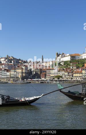 Rabelos, Boote auf der Promenade von Vila Nova de Gaia mit Blick auf die historischen Hausfassaden von Cais da Ribeira am Fluss Douro und den Torre dos Stockfoto