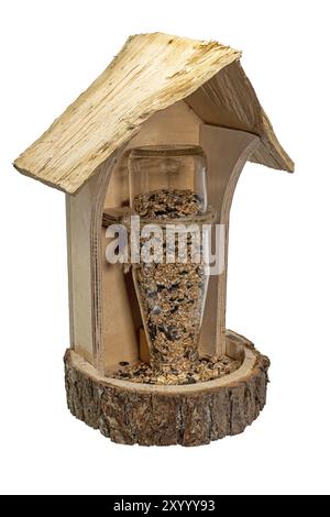 Hausgemachte Holzvogelfütterungsanlage mit Glasflasche und Vogelsaat auf weiß Stockfoto