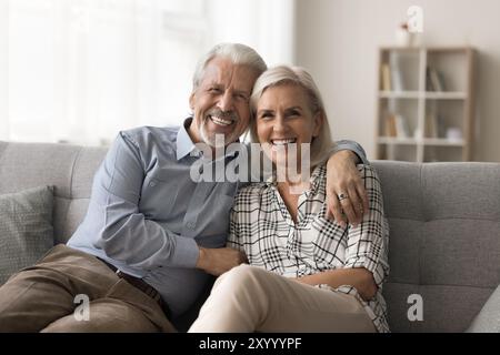 Porträt eines attraktiven alten Pensionärs, das sich auf dem Sofa umarmt Stockfoto