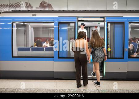 München, Deutschland. 31. August 2024. Zwei Besucher des Konzerts Adele besteigen am Königsplatz eine U-Bahn der Linie U2. Quelle: Lukas Barth/dpa/Alamy Live News Stockfoto