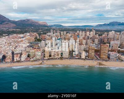 Luftdrohne aus Sicht der Stadt Benidorm. Berühmtes Reiseziel in der Provinz Alicante, Spanien. Wolkenkratzer, Berge im Hintergrund, Mediterranea Stockfoto