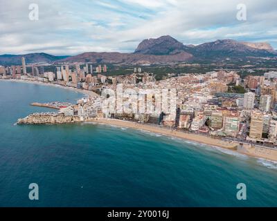 Luftdrohne aus Sicht der Stadt Benidorm. Berühmtes Reiseziel in der Provinz Alicante, Spanien. Wolkenkratzer, Berge im Hintergrund, Mediterranea Stockfoto