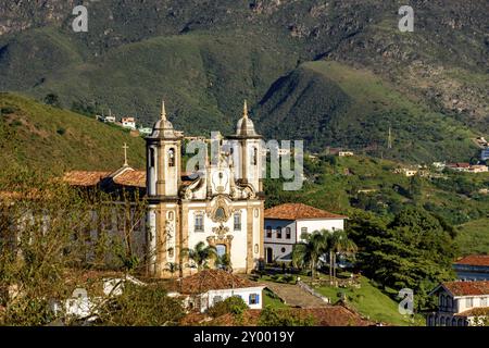 Blick auf eine von mehreren Kirchen und ihrem Glockenturm in Barock und koloniale Architektur der Stadt Ouro Preto in Minas Gerais mit seinen Bergen Stockfoto