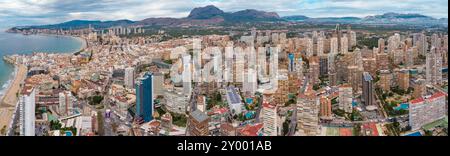 Luftdrohne aus Sicht der Stadt Benidorm. Berühmtes Reiseziel in der Provinz Alicante, Spanien. Wolkenkratzer, Berge im Hintergrund, Mediterranea Stockfoto