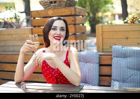 Close up Portrait von brünette Frau mit Polka Dots Kleid in Wein in einem Restaurant Stockfoto