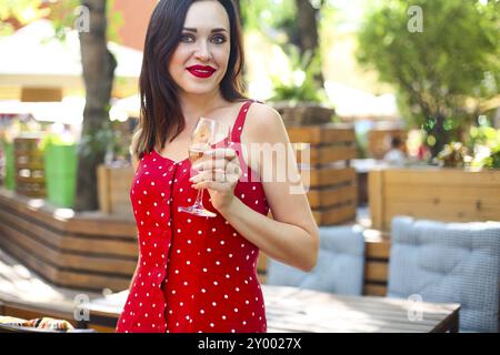 Close up Portrait von brünette Frau mit Polka Dots Kleid in Wein in einem Restaurant Stockfoto