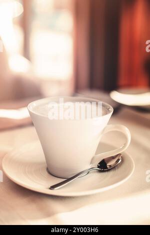 Tasse frischen Cappuccino am Morgen in der gemütlichen Cafeteria auf den Tisch gelegt Stockfoto