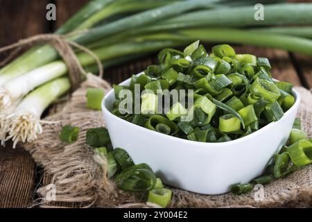 Frühlingszwiebeln (frisch geschnitten) als Nahaufnahme auf hölzernen Hintergrund Stockfoto