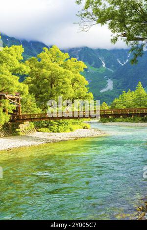 Man überquert die Kappa-Brücke mit dem Hotaka-Dake-Hintergrund am frühen sonnigen Morgen in Kamikochi in den Japanischen Alpen, Präfektur Nagano, Japan. Ve Stockfoto