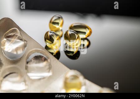 Ein Arrangement von gelben transparenten Kapseln, einschließlich Vitamin D und Omega-3-Fischöl Ergänzungen, die gesundheitliche Vorteile und Nährwert widerspiegeln Stockfoto