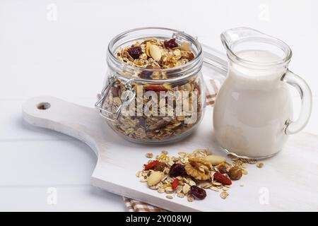 Schüssel hausgemachtes Müsli mit Nüssen, Beeren, getrockneten Früchten, Glas Milch und Honig. Gesundes Frühstück. Draufsicht Stockfoto