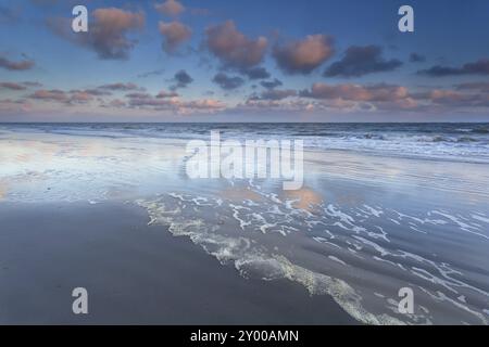 Sonnenaufgangshimmel spiegelt sich in den Wellen der Nordsee, Schiermonnikoog, Niederlande Stockfoto