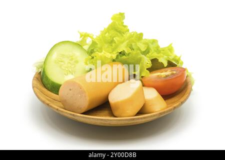 Würstchen, Gurke, Tomate und Salat in Holzplatte auf weißem Hintergrund Stockfoto