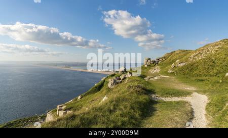 Blick vom South West Coast Path in Richtung Fortuneswell und Chesil Beach, Isle of Portland, Jurassic Coast, Dorset, Großbritannien, mit Wolken über Weymouth Stockfoto