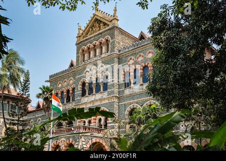 Polizeipräsidium Maharashtra, Colaba, Mumbai, Indien. Das Hauptquartier der Staatspolizei an einem sonnigen Tag. Fassade eines Polizeigebäudes mit indischer Flagge in Mumb Stockfoto