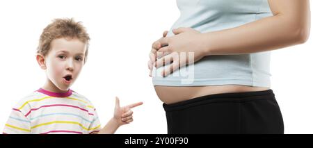 Wenig erstaunt oder überrascht Kind Jungen Zeigefinger zeigt seine schwangere Mutter Bauch weiß isoliert Stockfoto