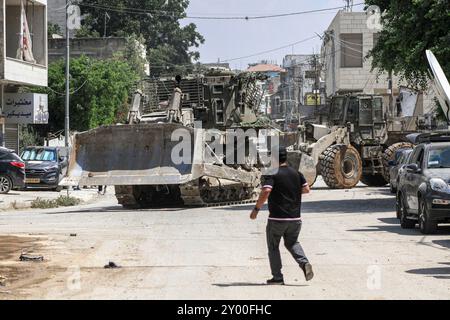 Jenin, Palästina. 31. August 2024. Israelische Bulldozer fahren während eines Armeeangriffs in Dschenin in eine Straße. Die israelische Armee sagte, zwei Palästinenser seien über Nacht getötet worden, als sie sich auf die Bombenangriffe im besetzten Westjordanland vorbereiteten, wo am vierten Tag eine israelische Operation begann. Quelle: SOPA Images Limited/Alamy Live News Stockfoto