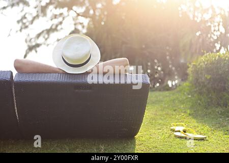 Entspannt Frau mit Hut am Strand bei Sonnenuntergang sitzen Stockfoto