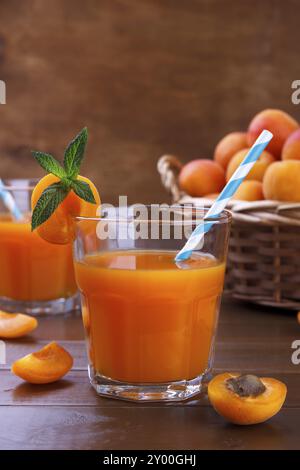 Großaufnahme von frischem Saft mit Aprikosen in einem Korb auf hölzernem Hintergrund Stockfoto