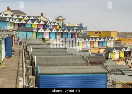 Walton-on-the-Naze, Essex, England, UK, 29. Mai, 2017: Reihen von Strandhütten an der Southcliff Promenade, mit einigen Leuten und dem Walton Pier hinten Stockfoto