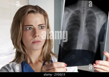 Besorgt Ärztin Blick auf eine Röntgenaufnahme Stockfoto